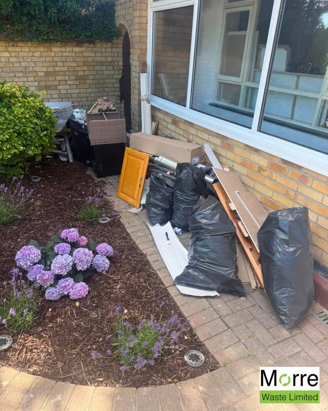 Renovation waste piled against a house wall before removal